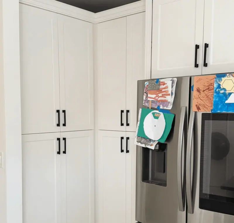 After: refinished white pantry cabinets with black handles