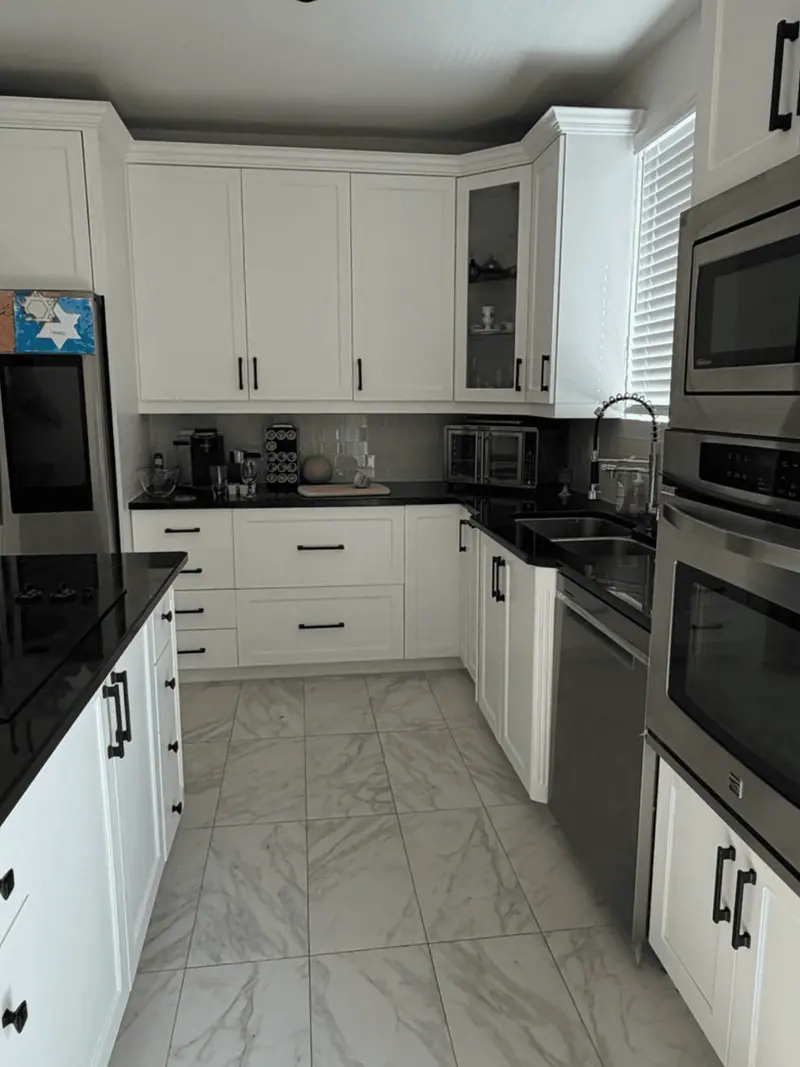 After: white cabinets with black countertops and stainless wall ovens, Hallandale Beach
