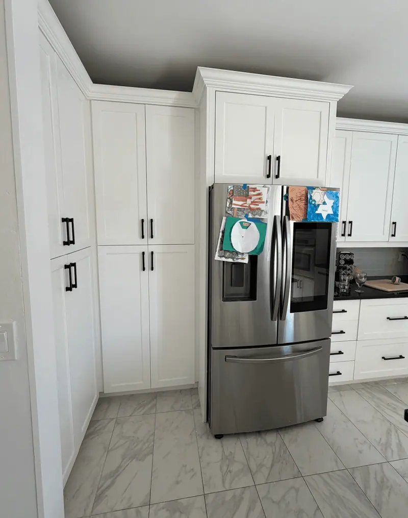 After: white pantry and upper cabinets with a clean, stain-free finish
