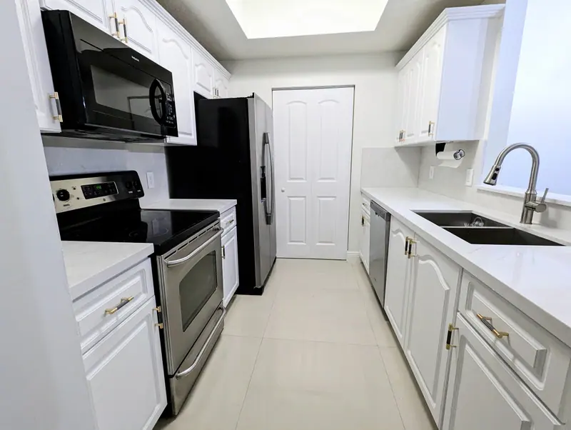 And this is how the kitchen transforms after painting the cabinets and updating the countertop, in this case, with a sleek quartz surface, giving a modern, durable, and high-end finish