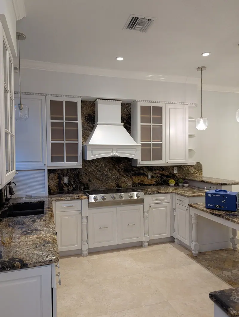 Aventura kitchen after painting, white Snowbound cabinets with range hood and stainless appliances
