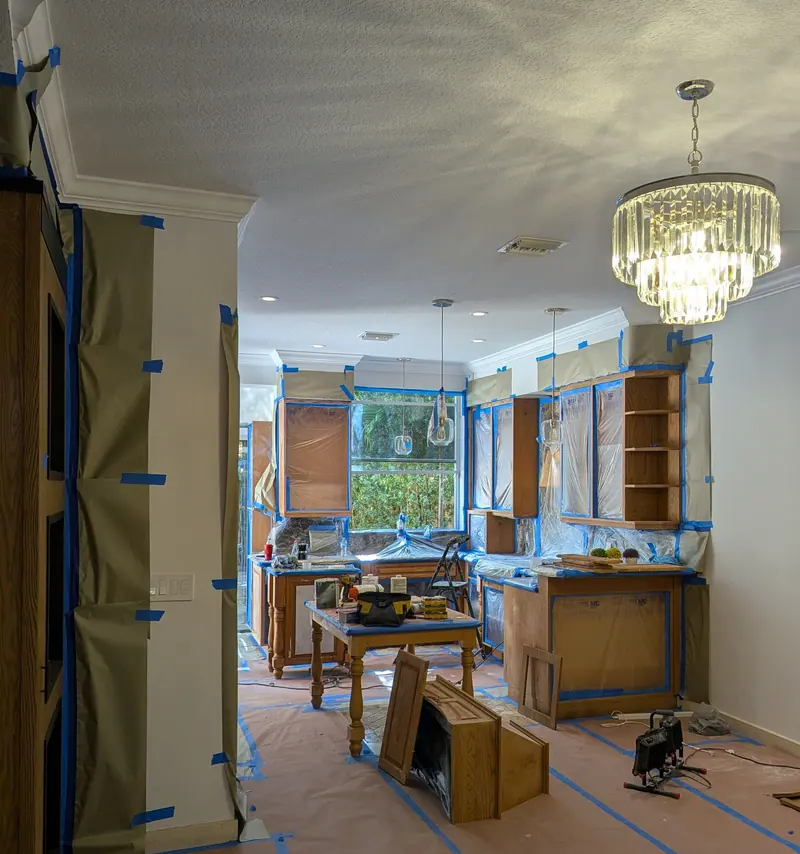 Aventura kitchen with chandelier and window view before cabinet refinishing