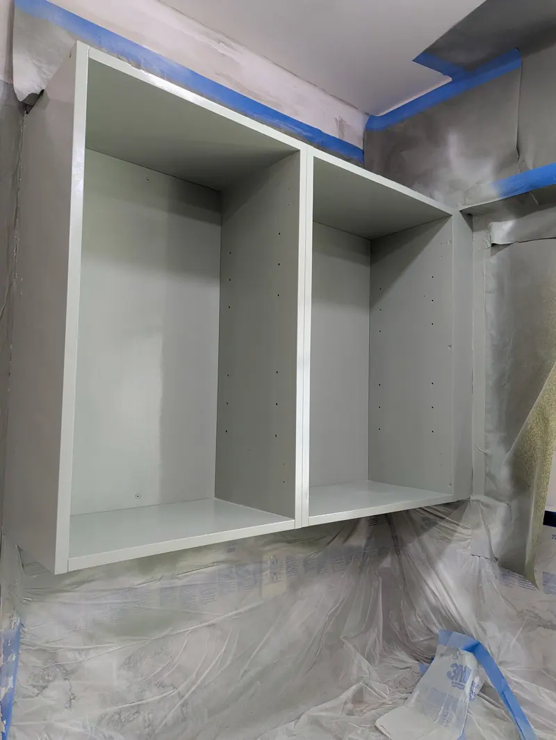 Close-up of a refinished cabinet box interior with a smooth sprayed finish