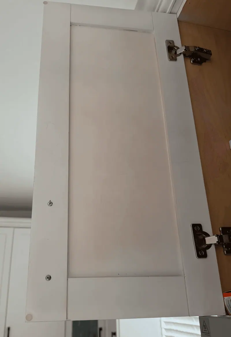 Close-up of a white cabinet door with tannin stains bleeding through a previous contractor's finish, Hallandale Beach