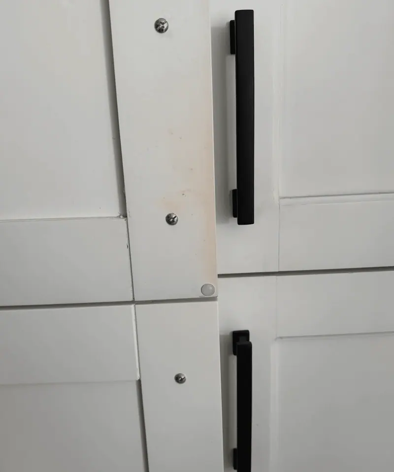 Close-up of refinished white shaker doors with black pulls