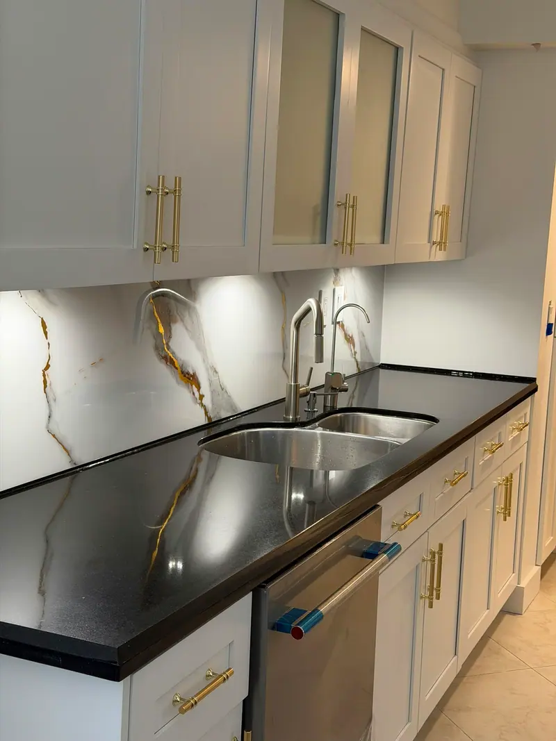 Close-up of white shaker cabinets beside the undermount sink and black countertop, Sunny Isles Beach