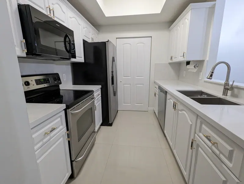 Coral Gables galley kitchen with white Snowbound cabinets and new countertops