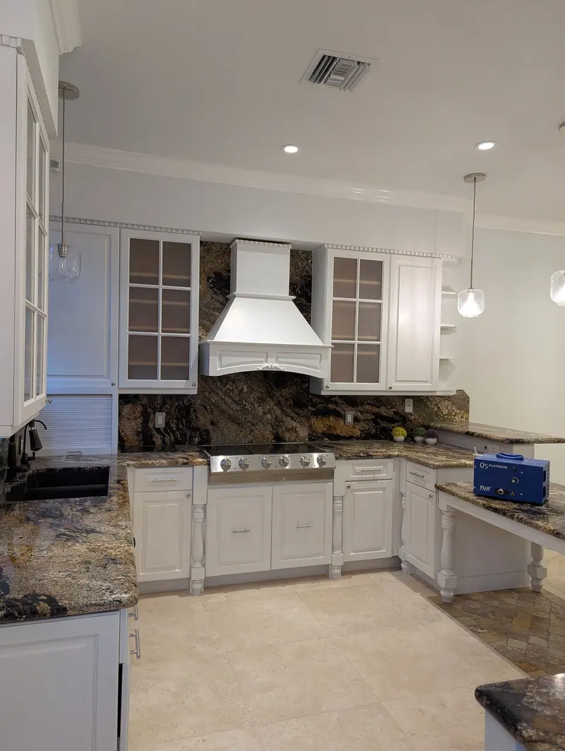 Finished Aventura kitchen with factory-smooth white cabinets and range hood