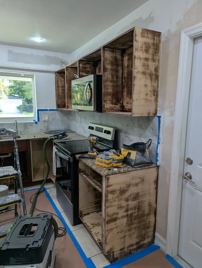 North Miami kitchen before refinishing, dark wood cabinets with prep underway