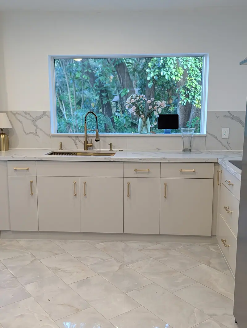 Refinished beige lower cabinets with marble backsplash in the Fort Lauderdale kitchen