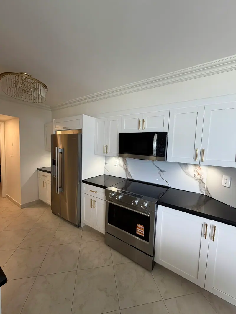 Sunny Isles Beach kitchen after painting, white shaker cabinets with stainless range and refrigerator
