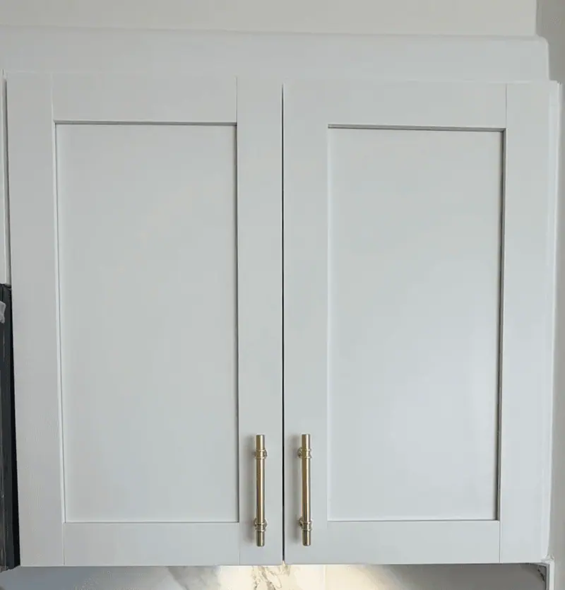 The same shaker cabinet doors after painting in white Alabaster with gold pulls