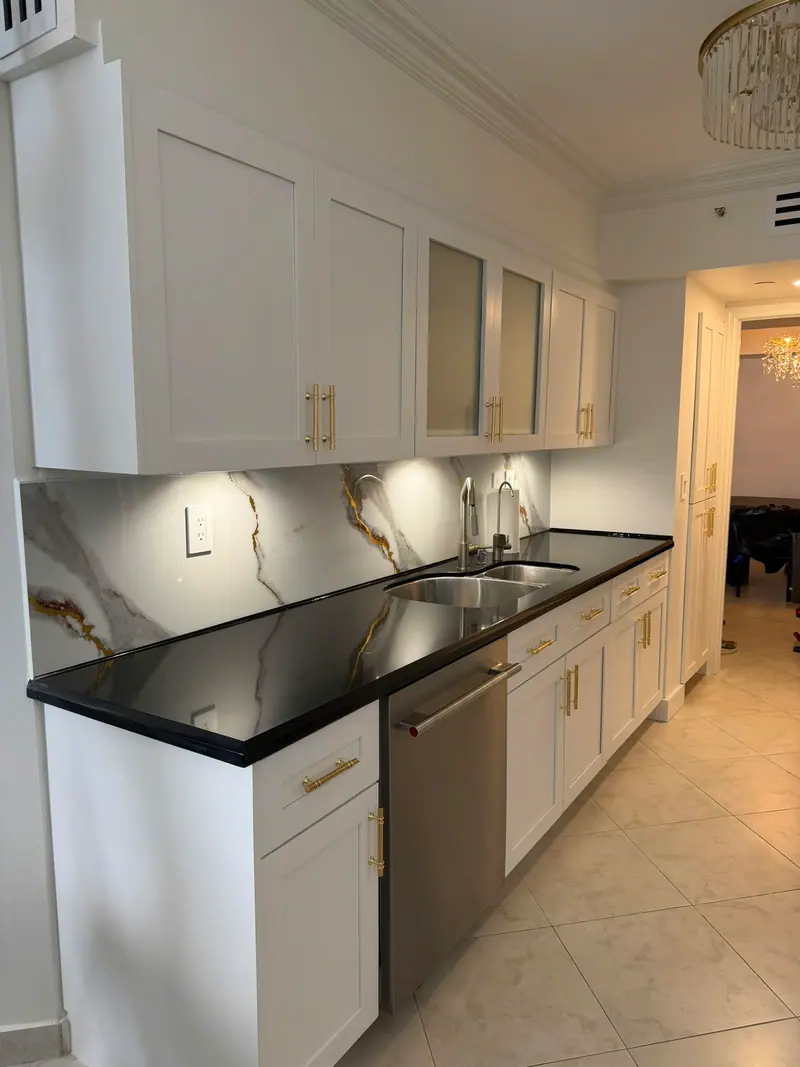 White shaker cabinets with gold hardware and black countertop after painting, Sunny Isles Beach