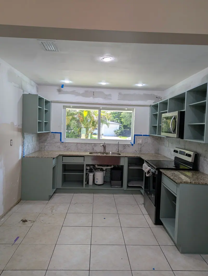 Wide view of refinished gray-green cabinet boxes ready for new custom doors, North Miami